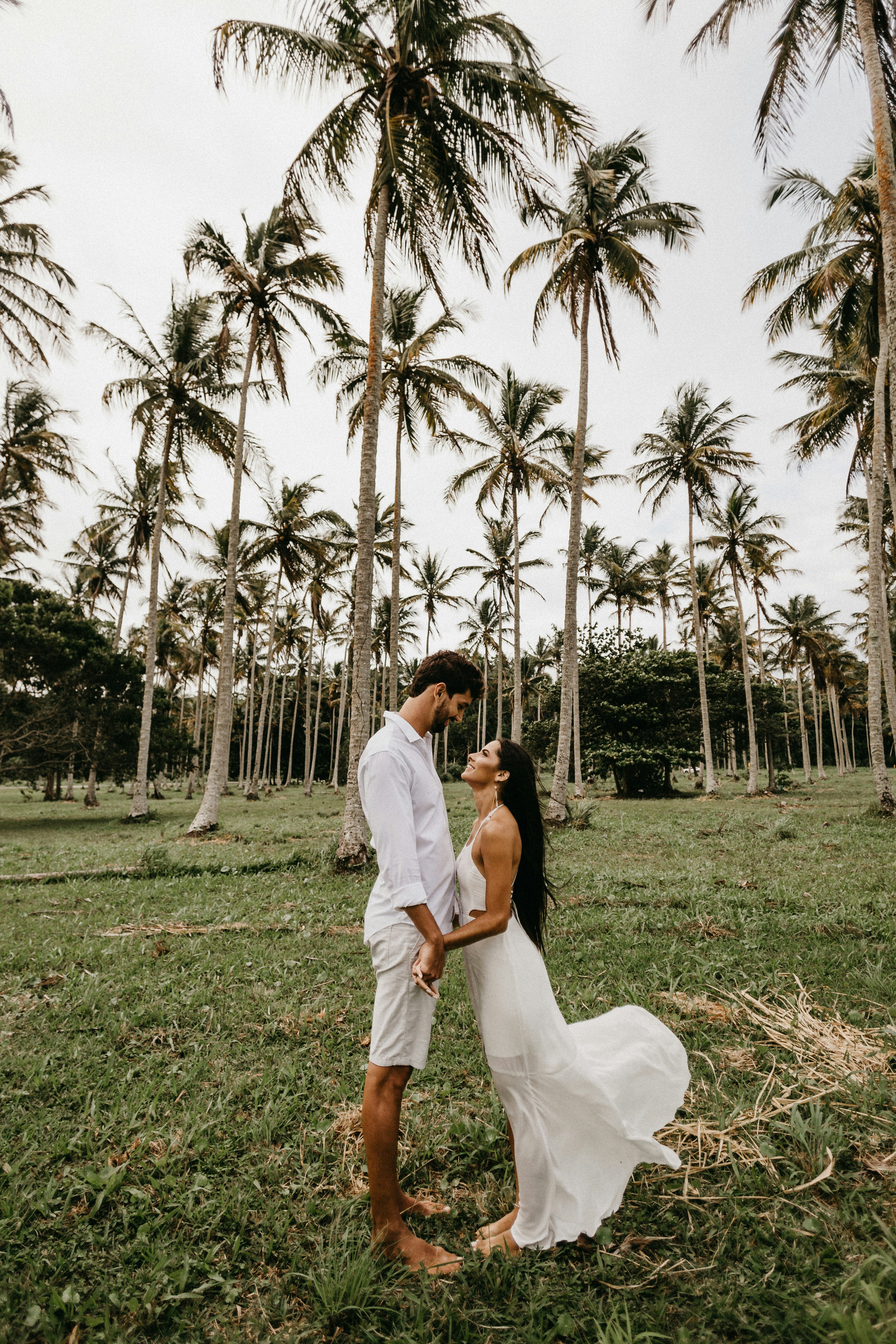 man and woman kissing on green grass field during daytime